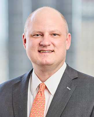 Trey Kampfer professional headshot with blurred office window background