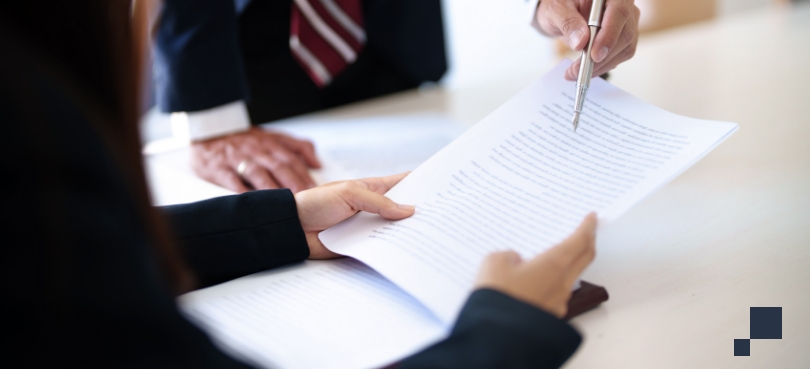 Mass tort and environmental claims paperwork on desk being reviewed by two people